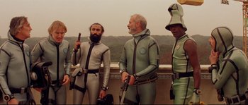 Movie still from “The Life Aquatic with Steve Zissou” (2004), directed by Wes Anderson – A group of men in scuba suits standing next to each other; Medium shot, Low angle