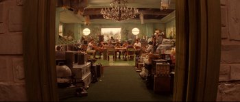 Movie still from “The Life Aquatic with Steve Zissou” (2004), directed by Wes Anderson – A group of people sitting around a table in a room; Wide shot, High angle
