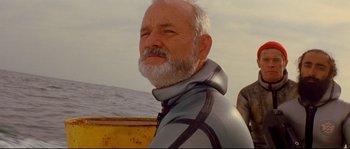 Movie still from “The Life Aquatic with Steve Zissou” (2004), directed by Wes Anderson – An older man in a wetsuit standing in front of a boat; Close Up shot, Low angle
