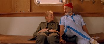 Movie still from “The Life Aquatic with Steve Zissou” (2004), directed by Wes Anderson – A man and a woman sitting on a bench; Medium shot, Low angle
