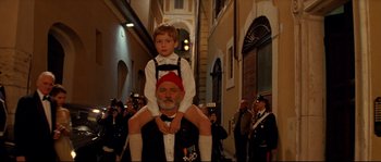 Movie still from “The Life Aquatic with Steve Zissou” (2004), directed by Wes Anderson – A man and a boy are standing in the street; Medium shot, Low angle
