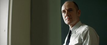 Movie still from “The Lives of Others” (2006), directed by Florian Henckel von Donnersmarck – A man in a suit and tie looking to his left; Close Up shot, Low angle