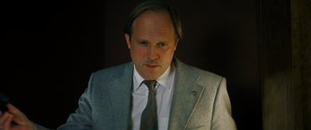 Movie still from “The Lives of Others” (2006), directed by Florian Henckel von Donnersmarck – A person wearing a suit and tie; Close Up shot, Low angle