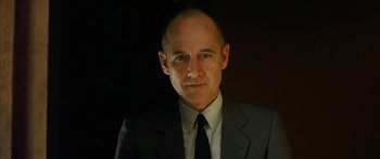 Movie still from “The Lives of Others” (2006), directed by Florian Henckel von Donnersmarck – A man wearing a suit and tie in the dark; Close Up shot, Low angle