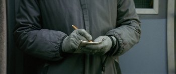 Movie still from “The Lives of Others” (2006), directed by Florian Henckel von Donnersmarck – A person wearing gloves writing on a piece of paper with a pencil; Extreme Close Up shot, High angle