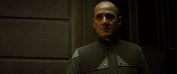 Movie still from “The Lives of Others” (2006), directed by Florian Henckel von Donnersmarck – A bald man in a uniform stands in front of a wall; Close Up shot, Low angle