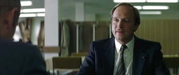 Movie still from “The Lives of Others” (2006), directed by Florian Henckel von Donnersmarck – A person wearing a suit and tie; Close Up shot, Low angle