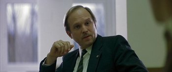 Movie still from “The Lives of Others” (2006), directed by Florian Henckel von Donnersmarck – A person wearing a suit and tie; Close Up shot, Low angle