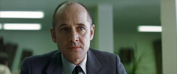 Movie still from “The Lives of Others” (2006), directed by Florian Henckel von Donnersmarck – A person wearing a suit and tie; Close Up shot, Low angle