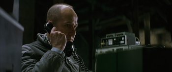 Movie still from “The Lives of Others” (2006), directed by Florian Henckel von Donnersmarck – A man talking on a phone in a dark room; Close Up shot, Low angle