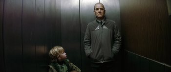 Movie still from “The Lives of Others” (2006), directed by Florian Henckel von Donnersmarck – A man standing next to a child in a elevator; Medium shot, Low angle