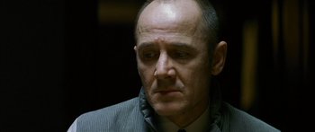 Movie still from “The Lives of Others” (2006), directed by Florian Henckel von Donnersmarck – A man in a suit and tie looking down; Close Up shot, Low angle