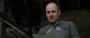 Movie still from “The Lives of Others” (2006), directed by Florian Henckel von Donnersmarck – A man in a gray jacket looking down at a piece of paper; Close Up shot, Low angle