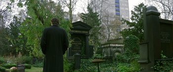 Movie still from “The Lives of Others” (2006), directed by Florian Henckel von Donnersmarck – A man standing in front of a grave in a cemetery; Wide shot, Over the shoulder angle