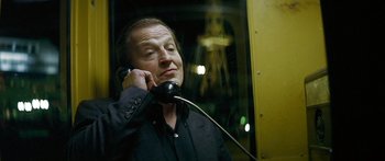 Movie still from “The Lives of Others” (2006), directed by Florian Henckel von Donnersmarck – A man talking on a phone while sitting in a bus; Close Up shot, Low angle