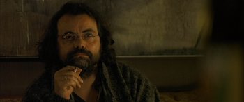 Movie still from “The Lives of Others” (2006), directed by Florian Henckel von Donnersmarck – A man with a beard wearing glasses and a robe; Close Up shot, Low angle