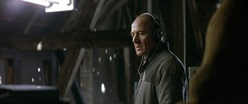 Movie still from “The Lives of Others” (2006), directed by Florian Henckel von Donnersmarck – A bald man wearing headphones and looking to his left; Close Up shot, Over the shoulder angle