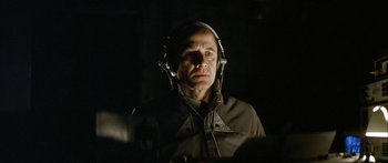 Movie still from “The Lives of Others” (2006), directed by Florian Henckel von Donnersmarck – A man wearing headphones and a jacket in the dark; Close Up shot, Low angle