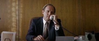 Movie still from “The Lives of Others” (2006), directed by Florian Henckel von Donnersmarck – A man sitting at a desk talking on a phone; Close Up shot, Low angle
