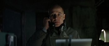 Movie still from “The Lives of Others” (2006), directed by Florian Henckel von Donnersmarck – A man is talking on a phone in a dark room; Close Up shot, Low angle