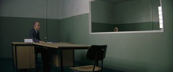 Movie still from “The Lives of Others” (2006), directed by Florian Henckel von Donnersmarck – A man sitting in front of a mirror in front of a desk; Wide shot, Over the shoulder angle