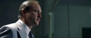 Movie still from “The Lives of Others” (2006), directed by Florian Henckel von Donnersmarck – A person wearing a suit and tie; Close Up shot, Low angle