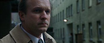 Movie still from “The Lives of Others” (2006), directed by Florian Henckel von Donnersmarck – A person wearing a suit and tie; Close Up shot, Over the shoulder angle