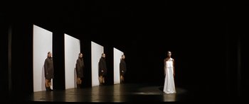 Movie still from “The Lives of Others” (2006), directed by Florian Henckel von Donnersmarck – A woman in a white dress standing in front of a row of white walls; Wide shot, Low angle