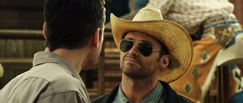 Movie still from “Real Steel” (2011), directed by Shawn Levy – A man wearing a straw hat and sunglasses talking to another man; Close Up shot, Over the shoulder angle