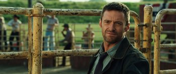 Movie still from “Real Steel” (2011), directed by Shawn Levy – A man in a suit and tie standing in front of a fence; Close Up shot, Over the shoulder angle