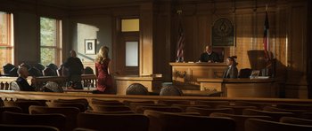 Movie still from “Real Steel” (2011), directed by Shawn Levy – A woman in a red dress sitting in front of a judge in a courtroom; Wide shot, Low angle