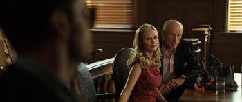 Movie still from “Real Steel” (2011), directed by Shawn Levy – A woman in a red dress sitting next to an older man; Medium shot, Over the shoulder angle