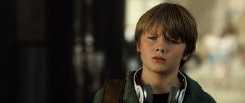 Movie still from “Real Steel” (2011), directed by Shawn Levy – A young boy with headphones and a green jacket; Close Up shot, High angle