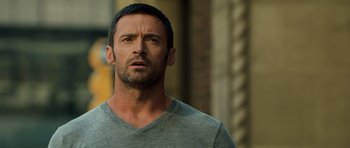 Movie still from “Real Steel” (2011), directed by Shawn Levy – A person wearing a gray t - shirt; Close Up shot, Over the shoulder angle
