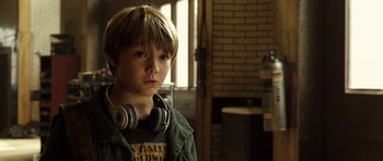 Movie still from “Real Steel” (2011), directed by Shawn Levy – A young boy with headphones on looking at the camera; Close Up shot, Over the shoulder angle