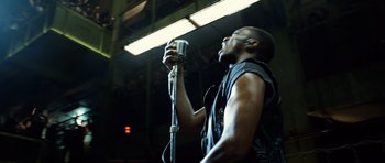 Movie still from “Real Steel” (2011), directed by Shawn Levy – A man holding a microphone up to his mouth; Close Up shot, Low angle