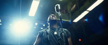 Movie still from “Real Steel” (2011), directed by Shawn Levy – A man is singing into a microphone in a dark room; Close Up shot, Low angle