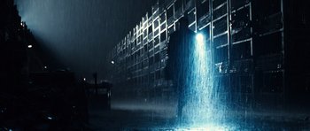 Movie still from “Real Steel” (2011), directed by Shawn Levy – A person standing in the rain with a light shining on him; Wide shot, Low angle