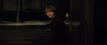 Movie still from “Real Steel” (2011), directed by Shawn Levy – A young boy smiling for the camera in the dark; Close Up shot, Over the shoulder angle