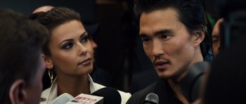 Movie still from “Real Steel” (2011), directed by Shawn Levy – A man and a woman are talking to a microphone; Close Up shot, Over the shoulder angle