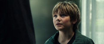Movie still from “Real Steel” (2011), directed by Shawn Levy – A young boy with blue eyes looking upward; Close Up shot, Low angle