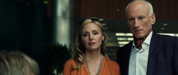 Movie still from “Real Steel” (2011), directed by Shawn Levy – A woman in an orange shirt and a man in a black suit; Close Up shot, Low angle