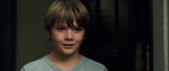 Movie still from “Real Steel” (2011), directed by Shawn Levy – A young boy with blue eyes is posing for a picture; Close Up shot, High angle