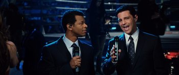 Movie still from “Real Steel” (2011), directed by Shawn Levy – Two men in suits are holding microphones and talking; Medium shot, High angle