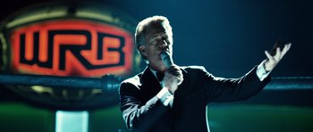 Movie still from “Real Steel” (2011), directed by Shawn Levy – A man in a black suit is singing into a microphone; Close Up shot, Low angle