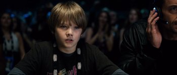 Movie still from “Real Steel” (2011), directed by Shawn Levy – A young boy is sitting in front of a group of people; Close Up shot, Over the shoulder angle