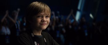 Movie still from “Real Steel” (2011), directed by Shawn Levy – A young boy smiling for the camera in front of an audience; Close Up shot, Over the shoulder angle
