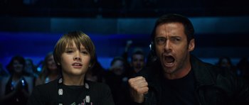Movie still from “Real Steel” (2011), directed by Shawn Levy – A man and a boy are playing a video game together; Close Up shot, Low angle