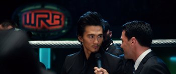 Movie still from “Real Steel” (2011), directed by Shawn Levy – A man in a black jacket is holding a microphone; Close Up shot, Over the shoulder angle