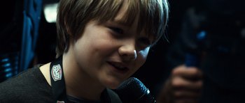 Movie still from “Real Steel” (2011), directed by Shawn Levy – A young boy is holding a microphone up to his face; Close Up shot, Over the shoulder angle